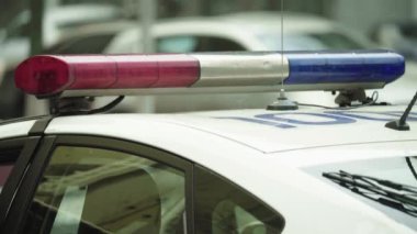 Polis teşhircisi devriye arabasının çatısında yanıp sönüyor.