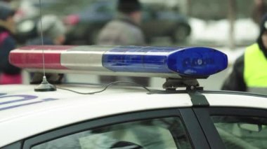 Polis teşhircisi devriye arabasının çatısında yanıp sönüyor.