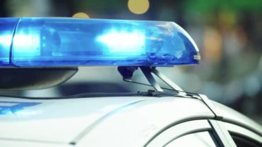 Polis teşhircisi devriye arabasının çatısında yanıp sönüyor.