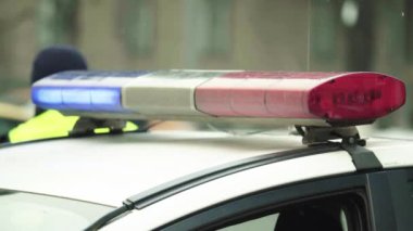 Polis teşhircisi devriye arabasının çatısında yanıp sönüyor.