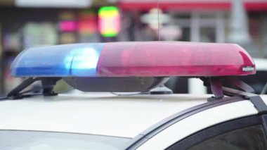 Polis teşhircisi devriye arabasının çatısında yanıp sönüyor.