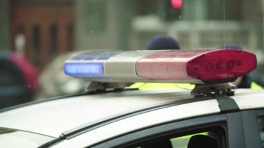 Polis teşhircisi devriye arabasının çatısında yanıp sönüyor.