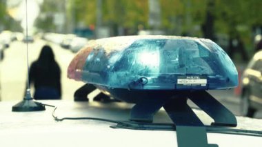 Polis teşhircisi devriye arabasının çatısında yanıp sönüyor.