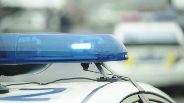 Polis teşhircisi devriye arabasının çatısında yanıp sönüyor.