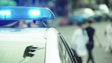 Polis teşhircisi devriye arabasının çatısında yanıp sönüyor.