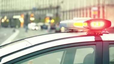 Polis teşhircisi devriye arabasının çatısında yanıp sönüyor.