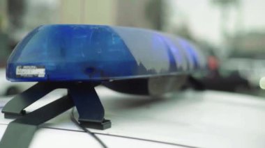 Polis teşhircisi devriye arabasının çatısında yanıp sönüyor.