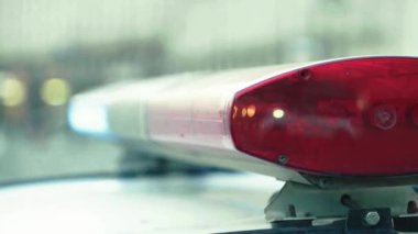 Polis teşhircisi devriye arabasının çatısında yanıp sönüyor.