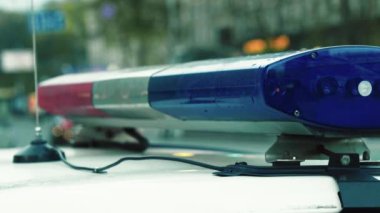 Polis teşhircisi devriye arabasının çatısında yanıp sönüyor.