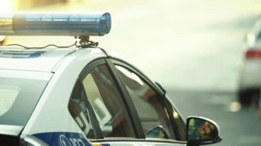 Polis teşhircisi devriye arabasının çatısında yanıp sönüyor.