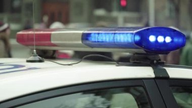 Polis teşhircisi devriye arabasının çatısında yanıp sönüyor.