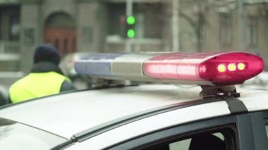 Polis teşhircisi devriye arabasının çatısında yanıp sönüyor.