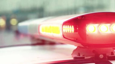 Polis teşhircisi devriye arabasının çatısında yanıp sönüyor.