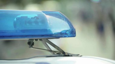 Polis teşhircisi devriye arabasının çatısında yanıp sönüyor.