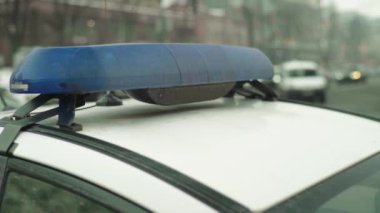 Polis teşhircisi devriye arabasının çatısında yanıp sönüyor.