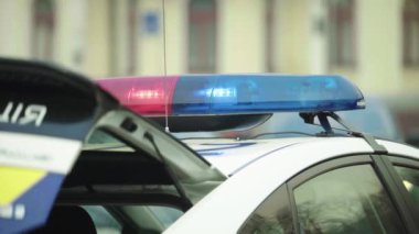 Polis teşhircisi devriye arabasının çatısında yanıp sönüyor.