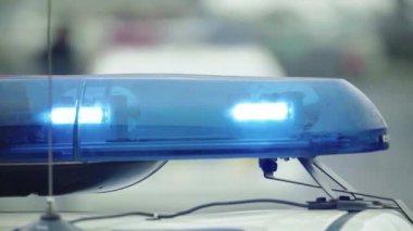 Polis teşhircisi devriye arabasının çatısında yanıp sönüyor.