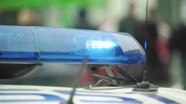 Polis teşhircisi devriye arabasının çatısında yanıp sönüyor.