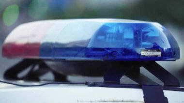 Polis teşhircisi devriye arabasının çatısında yanıp sönüyor.