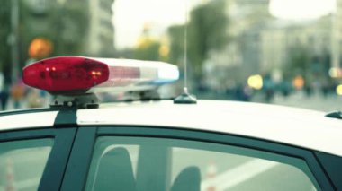 Polis teşhircisi devriye arabasının çatısında yanıp sönüyor.