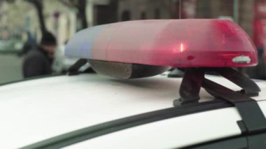 Polis teşhircisi devriye arabasının çatısında yanıp sönüyor.