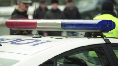 Polis teşhircisi devriye arabasının çatısında yanıp sönüyor.