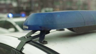 Polis teşhircisi devriye arabasının çatısında yanıp sönüyor.