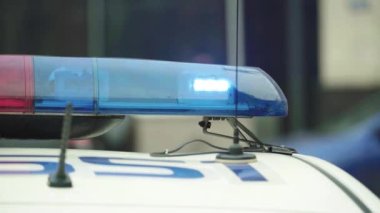 Polis teşhircisi devriye arabasının çatısında yanıp sönüyor.