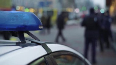 Polis teşhircisi devriye arabasının çatısında yanıp sönüyor.