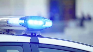 Polis teşhircisi devriye arabasının çatısında yanıp sönüyor.