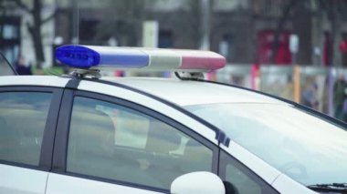 Polis teşhircisi devriye arabasının çatısında yanıp sönüyor.