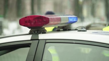 Polis teşhircisi devriye arabasının çatısında yanıp sönüyor.