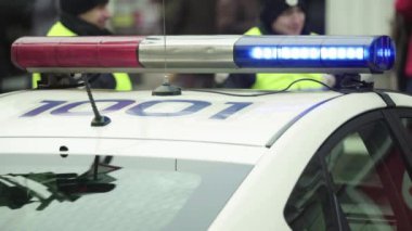 Polis teşhircisi devriye arabasının çatısında yanıp sönüyor.