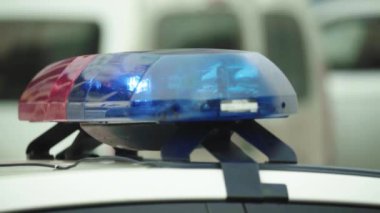 Polis teşhircisi devriye arabasının çatısında yanıp sönüyor.