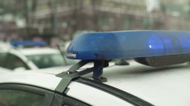 Polis teşhircisi devriye arabasının çatısında yanıp sönüyor.