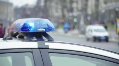 Polis teşhircisi devriye arabasının çatısında yanıp sönüyor.