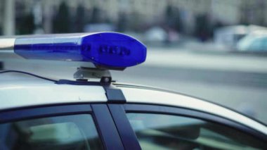 Polis teşhircisi devriye arabasının çatısında yanıp sönüyor.