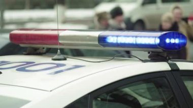 Polis teşhircisi devriye arabasının çatısında yanıp sönüyor.