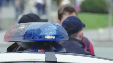Polis teşhircisi devriye arabasının çatısında yanıp sönüyor.