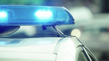 Polis teşhircisi devriye arabasının çatısında yanıp sönüyor.