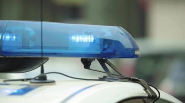Polis teşhircisi devriye arabasının çatısında yanıp sönüyor.