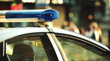 Polis teşhircisi devriye arabasının çatısında yanıp sönüyor.