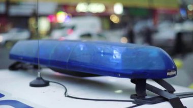 Polis teşhircisi devriye arabasının çatısında yanıp sönüyor.
