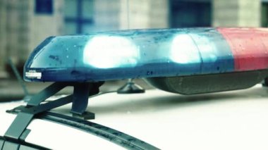Polis teşhircisi devriye arabasının çatısında yanıp sönüyor.