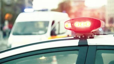 Polis teşhircisi devriye arabasının çatısında yanıp sönüyor.