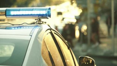 Polis teşhircisi devriye arabasının çatısında yanıp sönüyor.