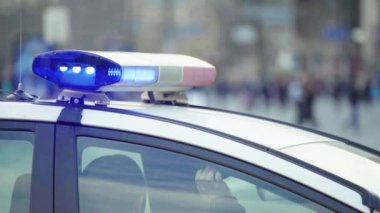 Polis teşhircisi devriye arabasının çatısında yanıp sönüyor.