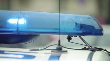 Polis teşhircisi devriye arabasının çatısında yanıp sönüyor.