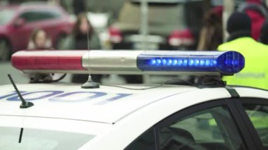 Polis teşhircisi devriye arabasının çatısında yanıp sönüyor.