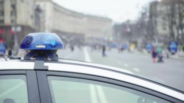 Polis teşhircisi devriye arabasının çatısında yanıp sönüyor.